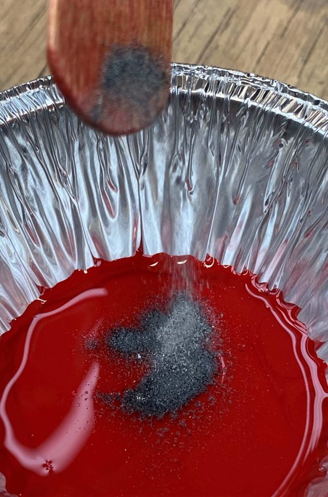 Steel filings being put in red liquid mixture 676x1024 - The story behind this year's RBL Masterpiece Poppy Coin